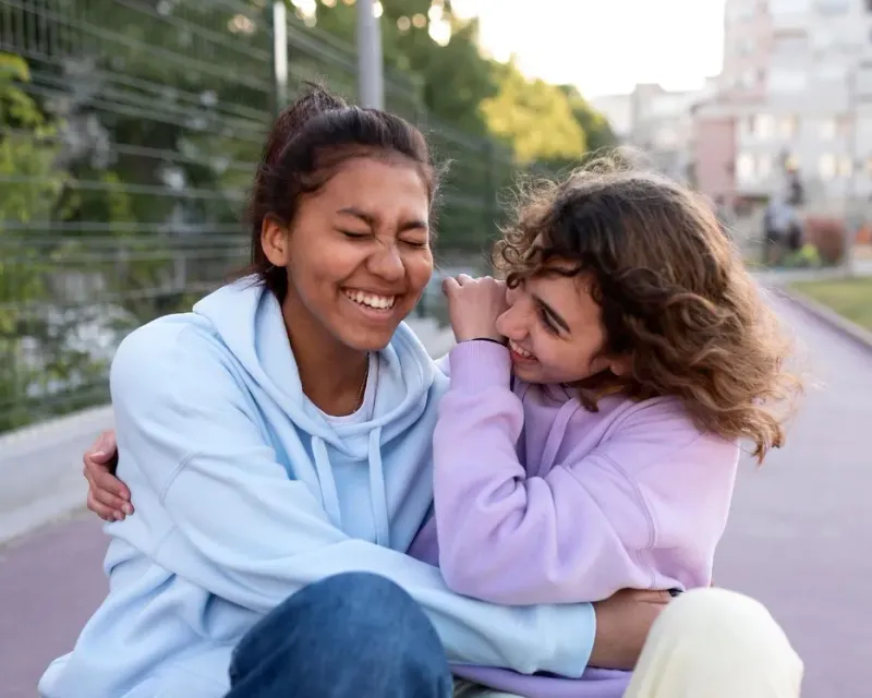 Two students laughing together outdoors